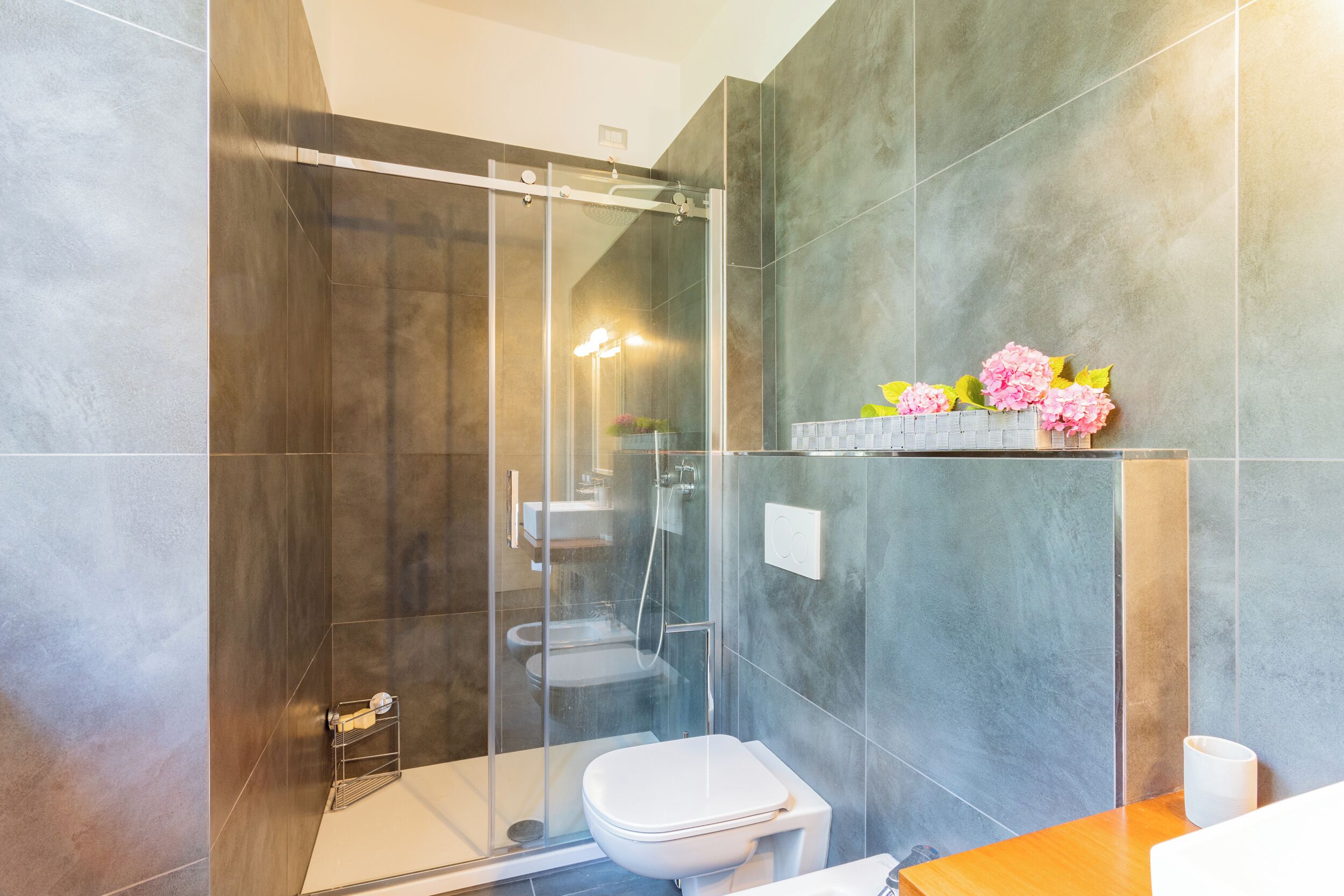 Ein modernes Badezimmer mit einer Duschkabine, einer Toilette und einem Waschbecken.