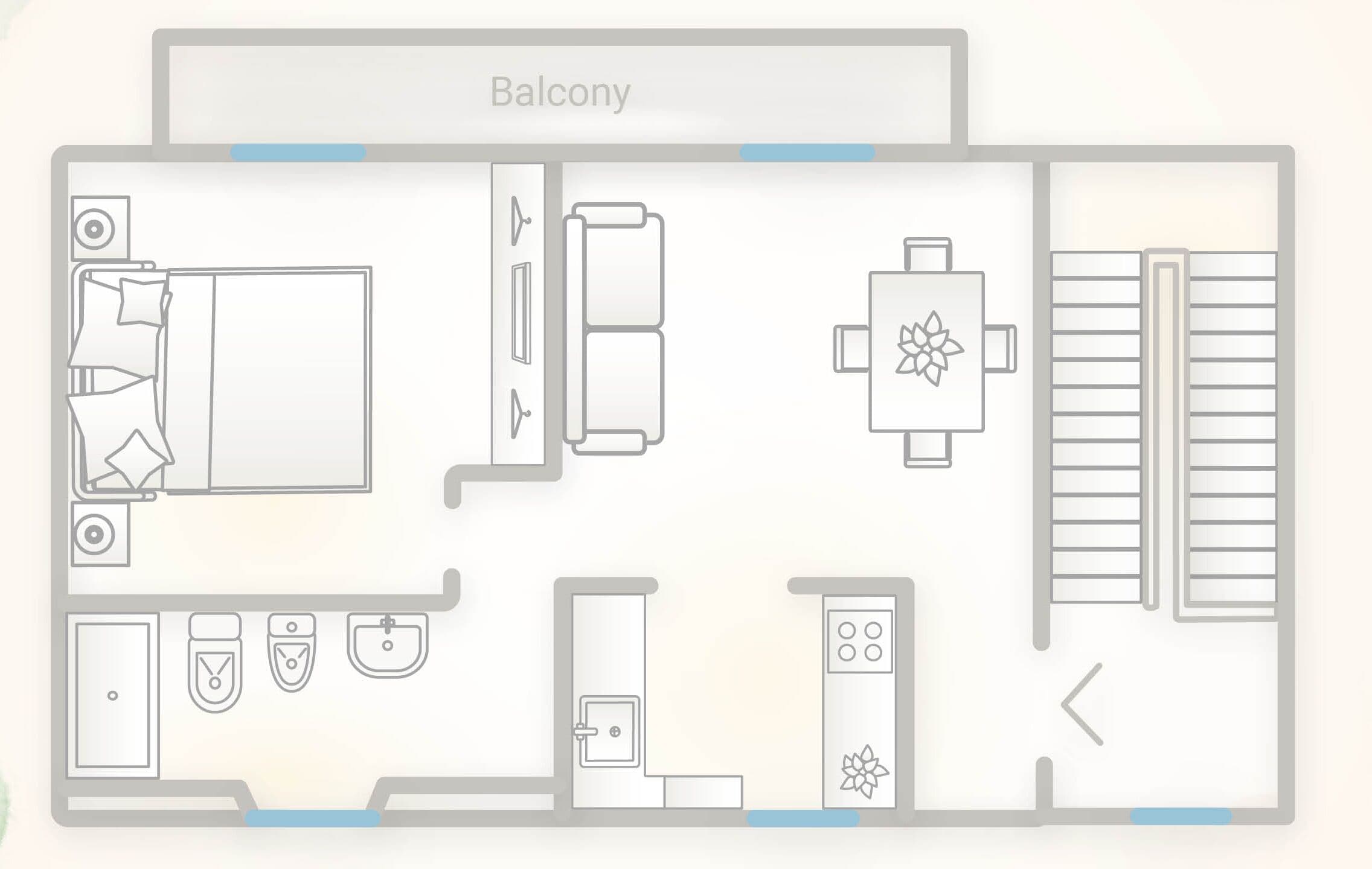 A hotel room layout with a balcony, a bed, a desk, a chair, a table, a sofa, a TV, a wardrobe, a bathroom with a sink and toilet, and a shower.