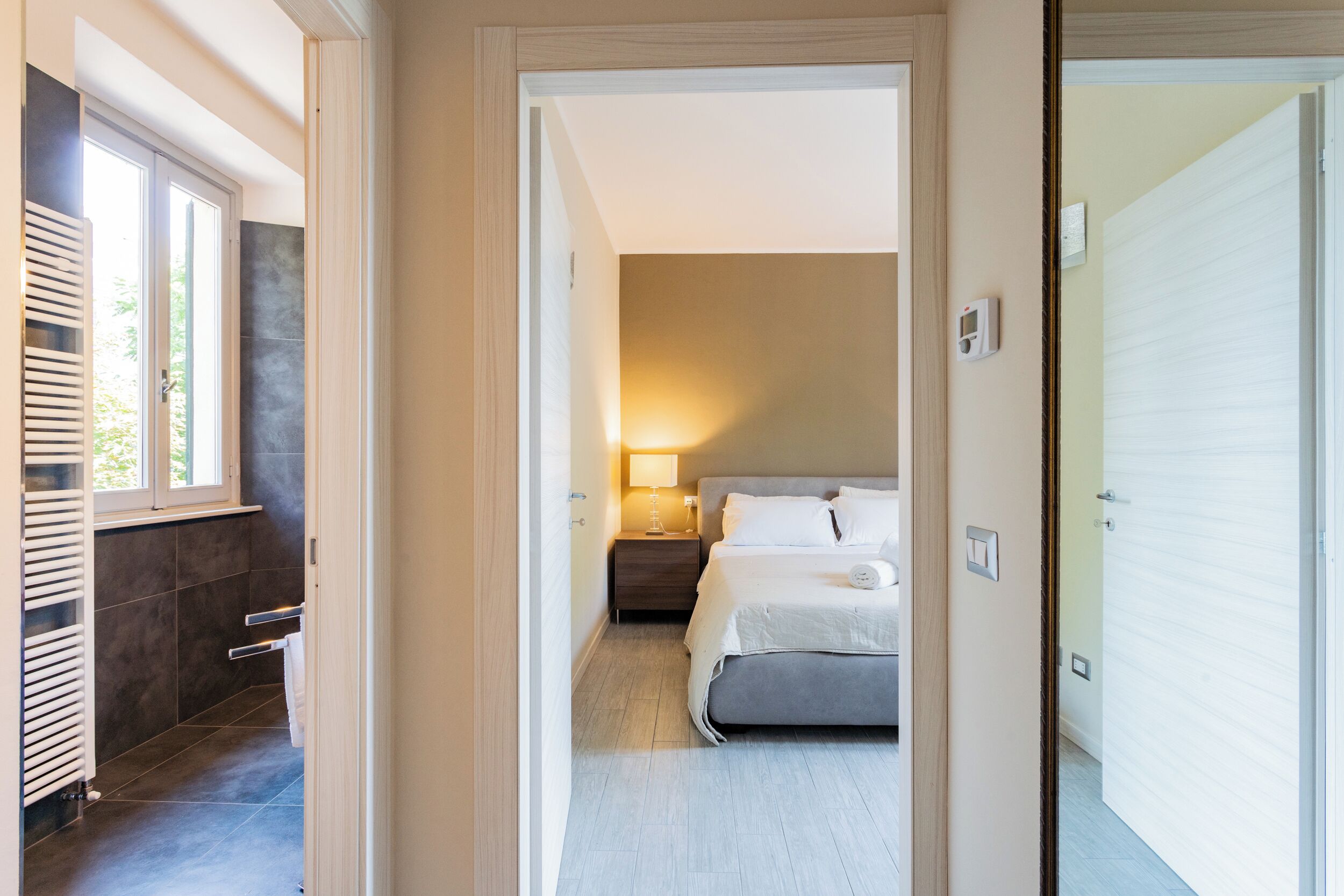 Ein modernes Schlafzimmer mit Bett, Nachttischen und einem Fenster.