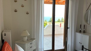 A bedroom with a bed, a bedside table with a lamp, a dresser, and a view of the outdoors. - "ever after" villa, romantic views and relaxation in pure serenity (Afytos)