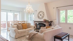 A cozy living room with a fireplace, a chandelier, and a large window. - Top Lake View Villetta by Rent all Como (Cernobbio)