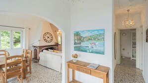 A cozy living room with a fireplace, a dining area, and a painting of a scenic landscape. - Top Lake View Villetta by Rent all Como (Cernobbio)