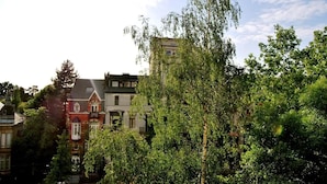 En række traditionelle europæiske bygninger med forskellig arkitektur, omgivet af frodig vegetation.