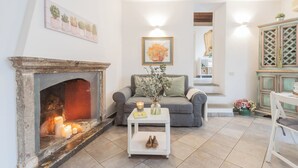 Un salon avec une cheminée, un canapé, une table basse et un escalier menant à un autre niveau.