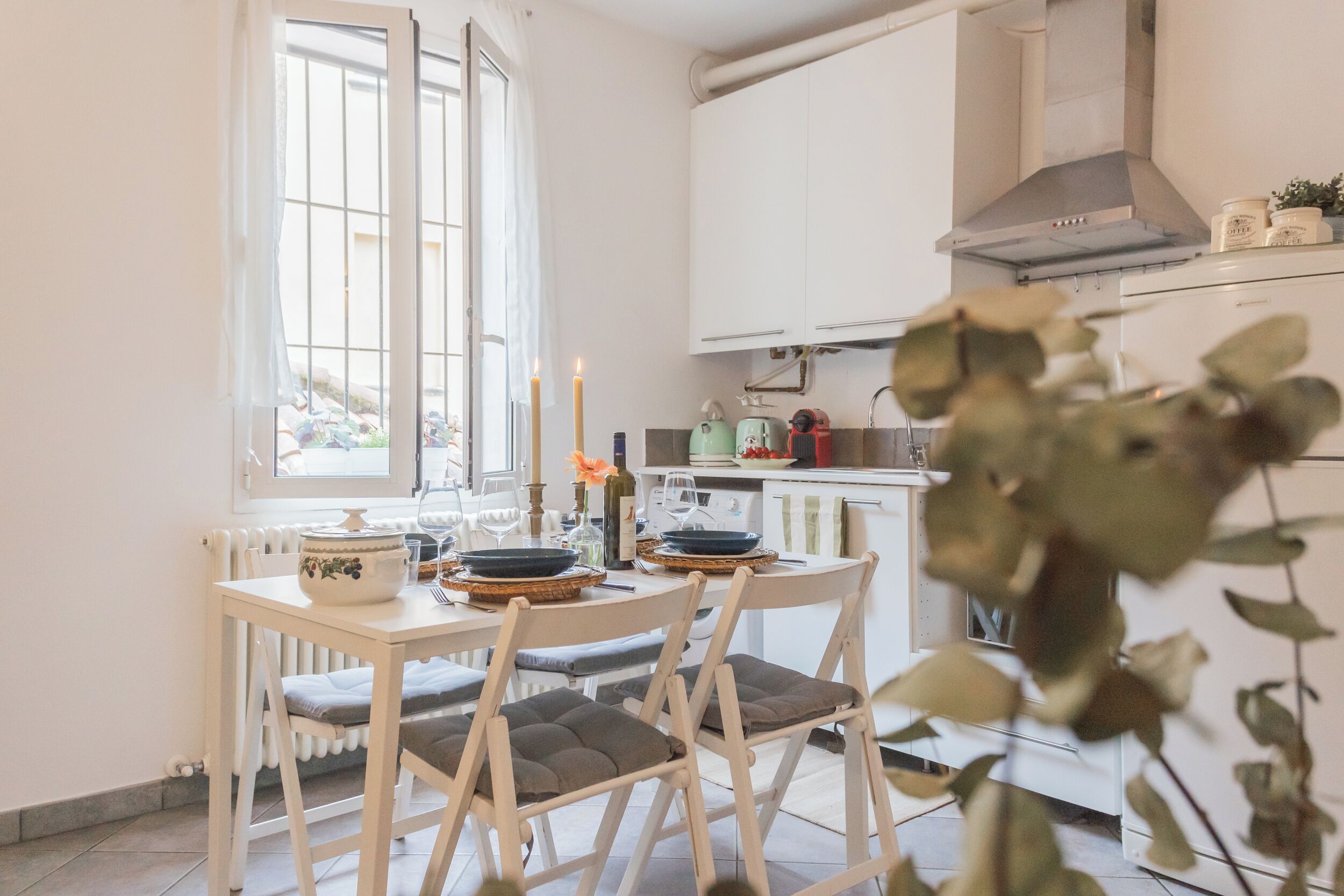 A kitchen with white cabinets, a stove, and a window with a view of parked bicycles.