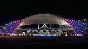 Het Setia Spice Convention Centre 's nachts, met een kenmerkend gebogen dak en verlichte bewegwijzering.