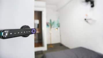 A door handle with a control panel, a bed, and a wall-mounted light fixture.