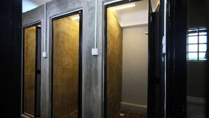 Een badkamer met betegelde vloer, toilet en douchehoek.