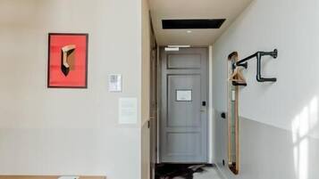 Un interior moderno con una escalera, un comedor y un pasillo que lleva a una puerta.