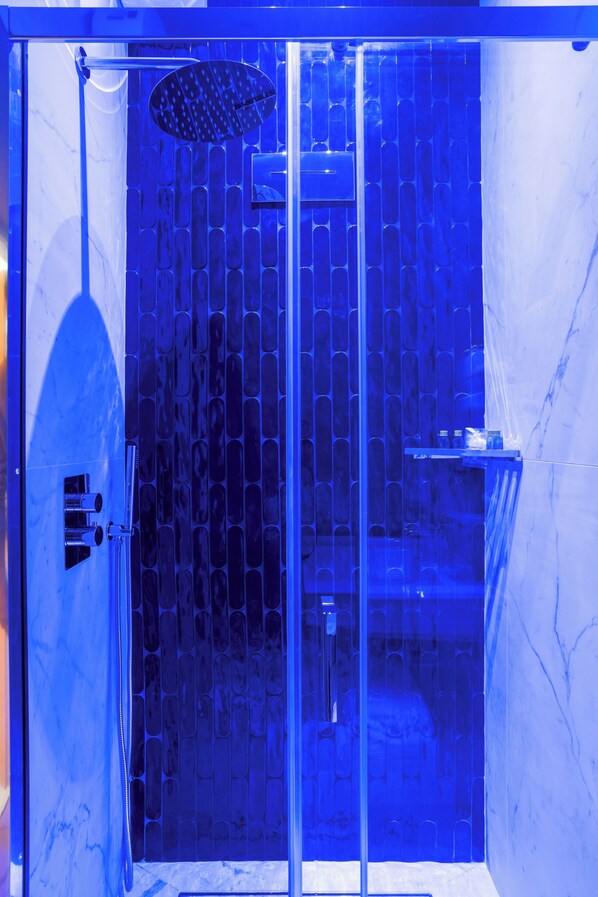 A modern bathroom with a glass shower enclosure, a marble wall, and a glass door. - Gh Trevi Fountain (Rome)
