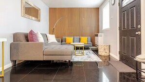 Una sala de estar moderna con un sofá, una mesa de centro y un televisor.