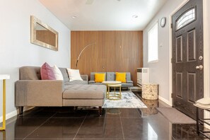 Una sala de estar moderna con un sofá, una mesa de centro y una alfombra estampada.