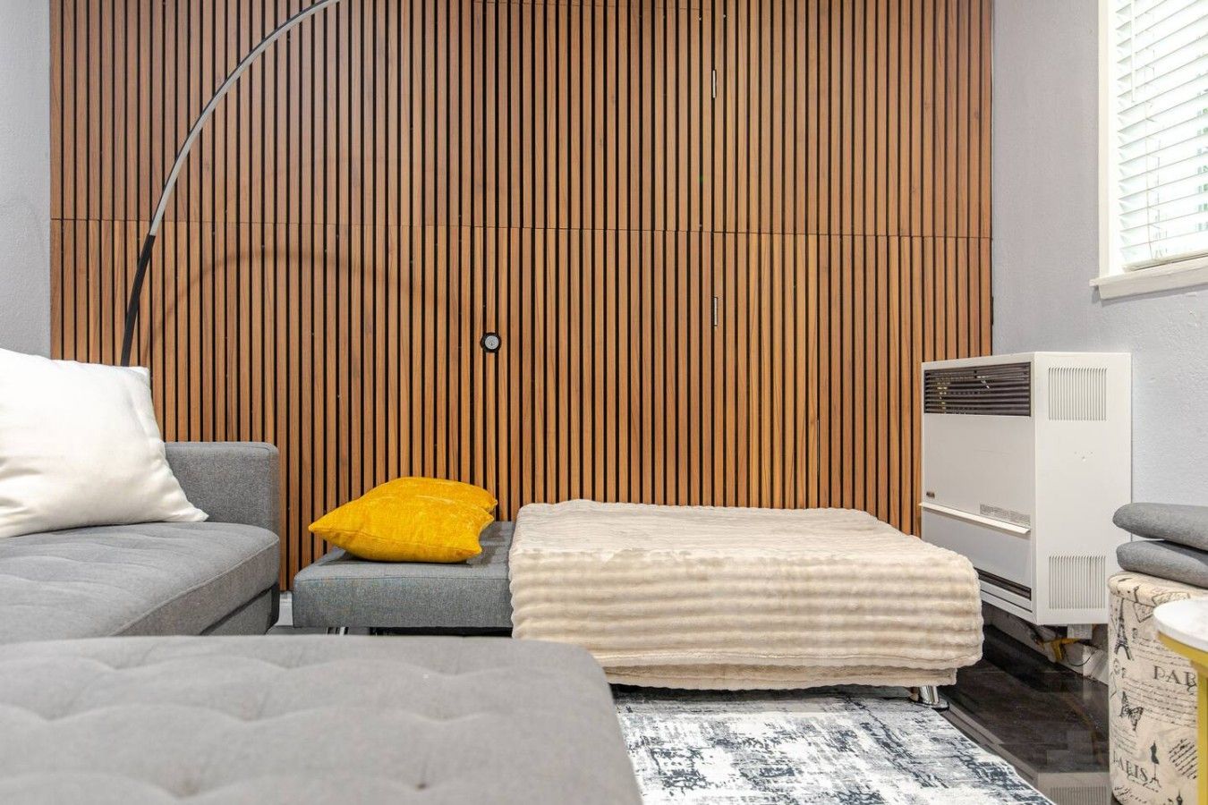 Ein modernes Zimmer mit einem Bett, einer Couch, einem kleinen Tisch und einer Heizung.