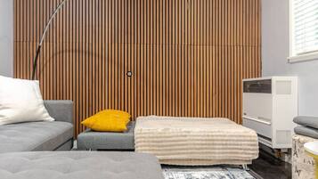 Ein modernes Zimmer mit einem Bett, einer Couch, einem kleinen Tisch und einer Heizung.