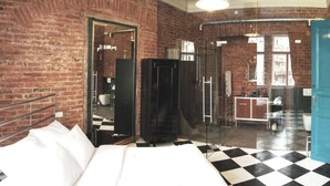 A hotel room with a bed, a bathroom, and a kitchenette.
