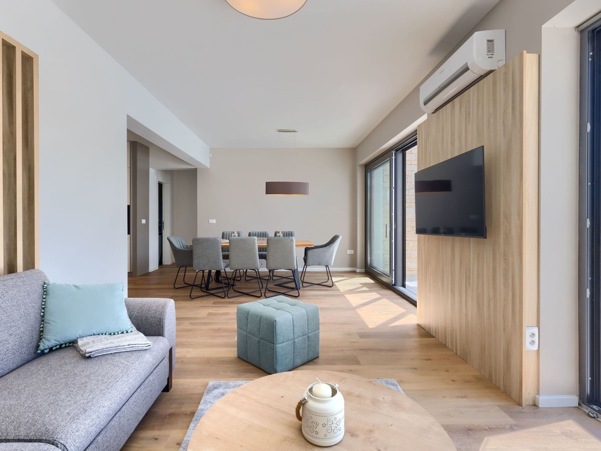 Un salon moderne comprenant un canapé, une table basse et un coin repas avec des chaises et une table.