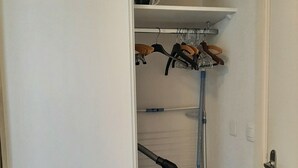 A narrow hallway with a door on the right, a vacuum cleaner, a mop, and a blue bucket. - Pti'Bonheur, apartment 4 pers (Toulouse)