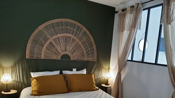 A bed with white linens and two brown pillows, flanked by two round tables with lamps, against a dark green wall. - Pti'Bonheur, apartment 4 pers (Toulouse)
