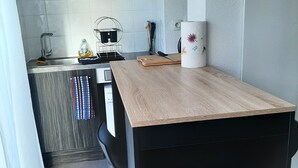 A compact kitchen with a wooden countertop, a built-in stove, and a small sink. - Pti'Bonheur, apartment 4 pers (Toulouse)