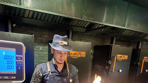 A person cooking with a torch at a counter, surrounded by cooking equipment and a digital scale. - New Cairo Gem 3BR Villa w/ Garden, Near Shopping & Dining by Best of Bed'z (cairo)