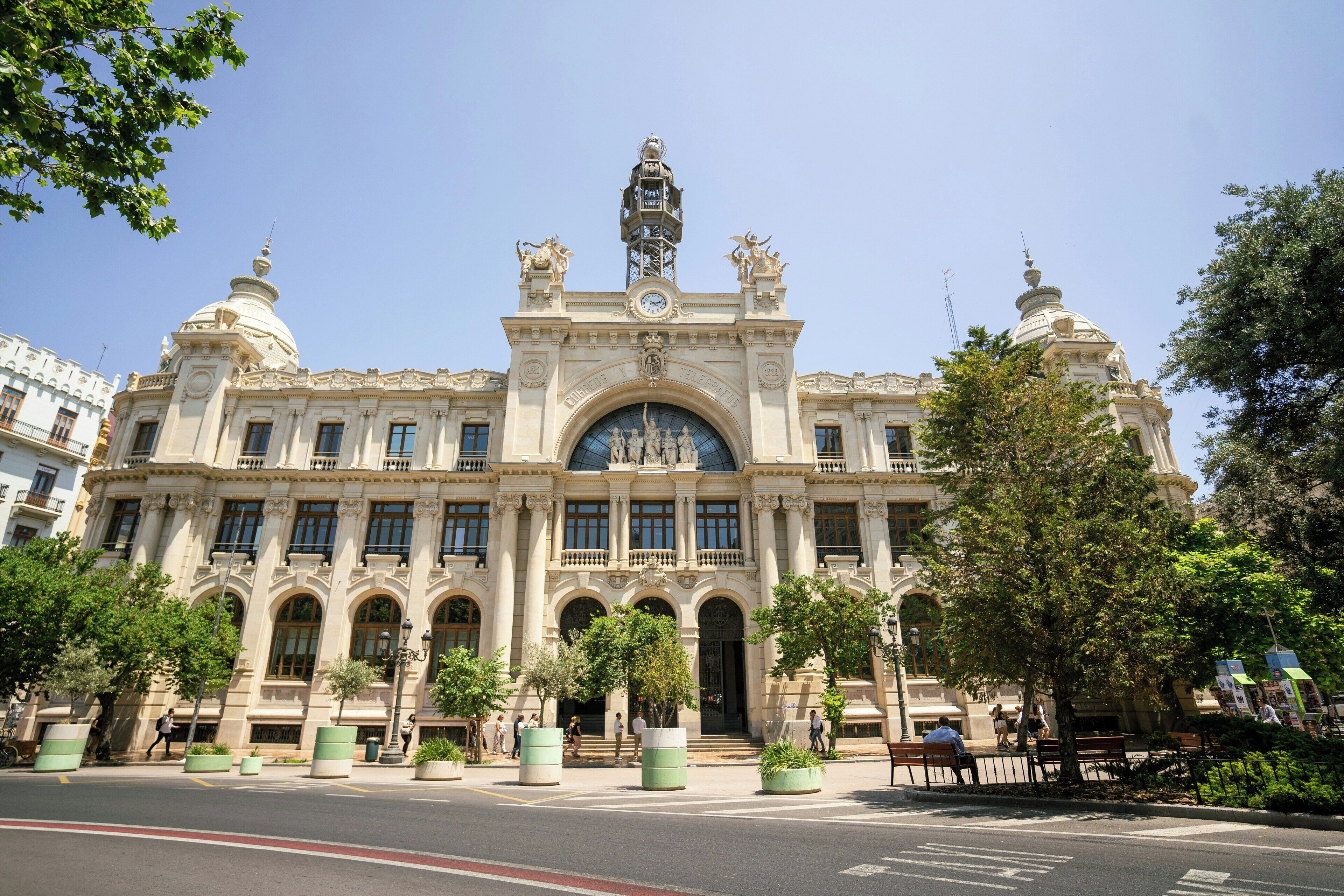 Un grand bâtiment imposant, orné d’une coupole centrale, de fenêtres en arc de cercle et de statues sur le toit.