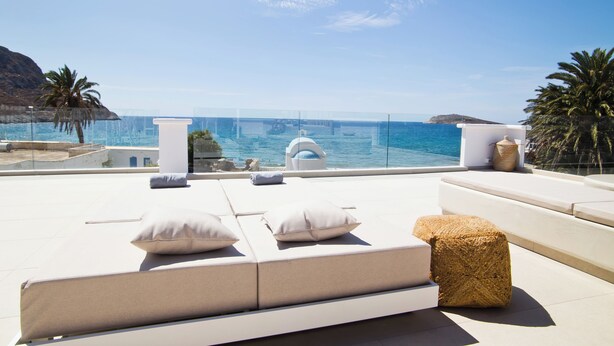 Une terrasse sur le toit offrant une vue sur la mer, avec un ensemble de canapés et une petite table.