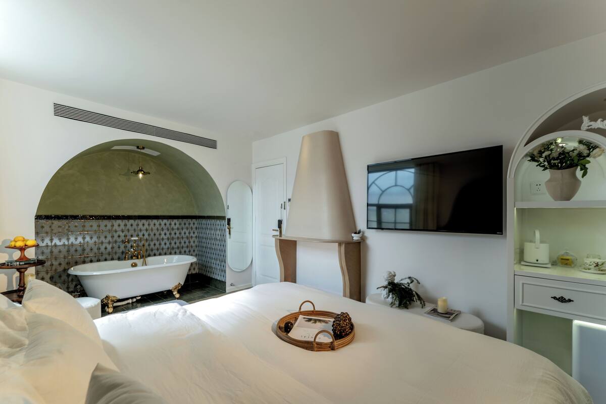 A modern bathroom with a freestanding bathtub, a vanity, and a large mirror.