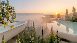 A serene outdoor pool area with a sunset view, surrounded by lush greenery and a misty atmosphere. - Dali Nest Secret Garden Lake View Inn (Dali)