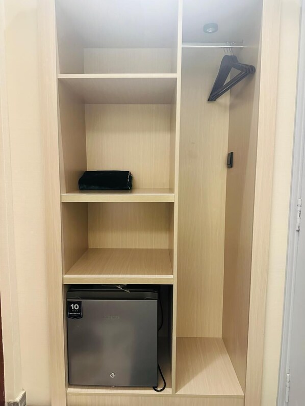 Ein begehbarer Kleiderschrank mit mehreren Regalen, einer Kleiderstange und einer kompakten Stauraum-Einheit.