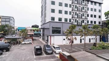 A multi-story building with a parking lot in front.