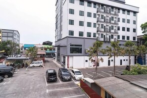 A multi-story building with a parking lot in front. - DJ Citi Plaza Hotel & Suites (Kuala Terengganu)