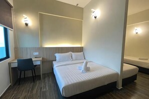 A hotel room with a bed, desk, chair, and a small window. - DJ Citi Plaza Hotel & Suites (Kuala Terengganu)