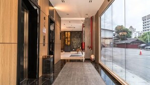 A modern hotel lobby with a marble floor, a reception desk, and a large window overlooking a parking area. - DJ Citi Plaza Hotel & Suites (Kuala Terengganu)