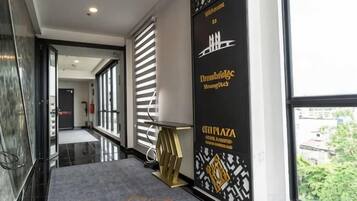 Et hotel med sort og guld tapet, en reception og udsigt til det fri.