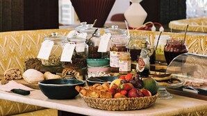 A buffet table with various food items and condiments, a patterned sofa, and decorative vases. - Repère Sauvage, Hôtel Lodges & Restaurant (La Ville-aux-Clercs)
