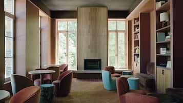 Una sala de estar moderna con chimenea, asientos cómodos y ventanas amplias.