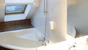 A modern bathroom with a skylight, a bathtub, and a shower. - Smart Appart Cherbourg La Rose des vents (Cherbourg-en-Cotentin)