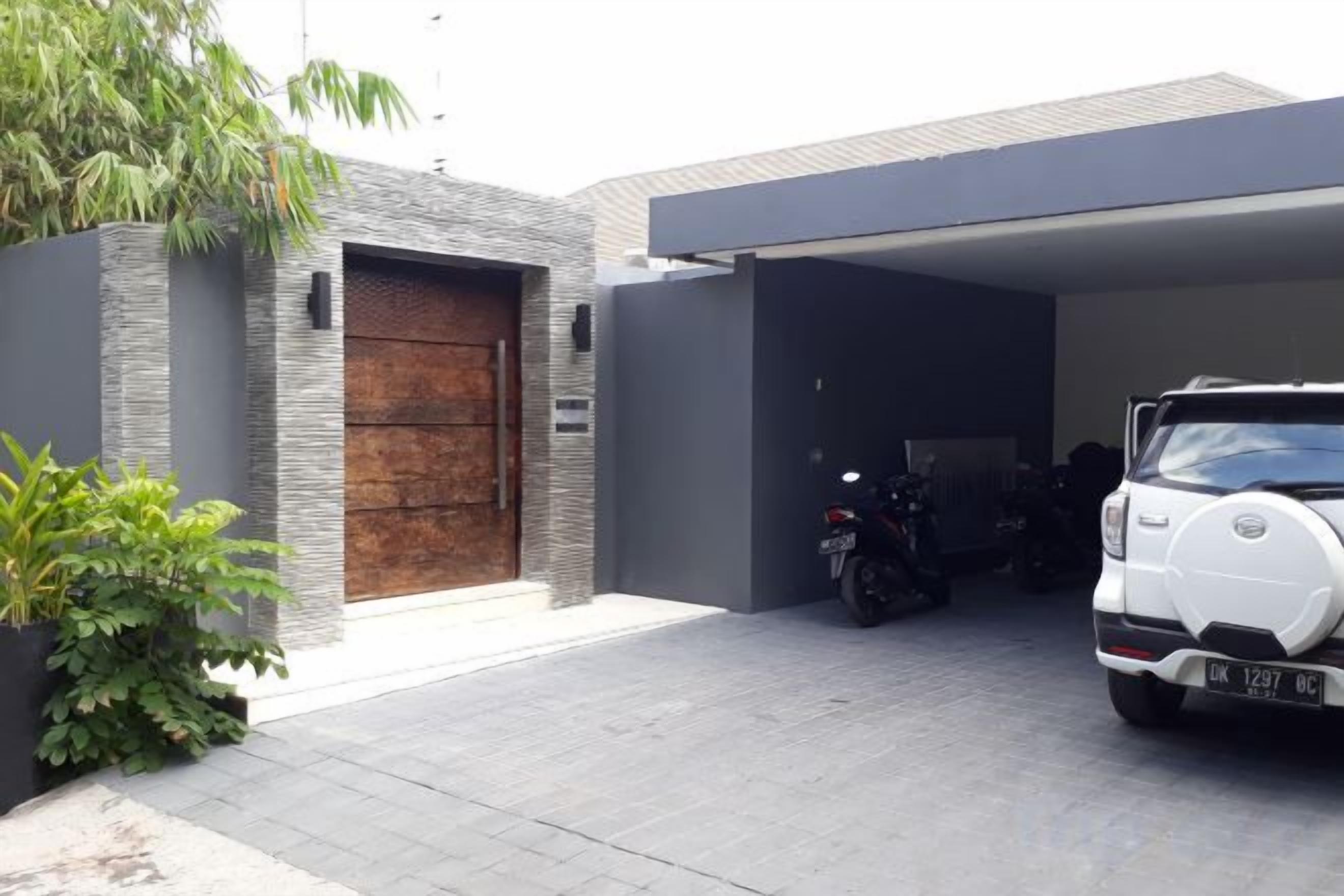 A modern garage with a car and a motorcycle parked inside.