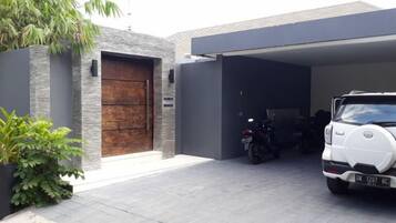 A modern garage with a car and a motorcycle parked inside.