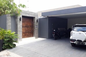 A modern garage with a car and a motorcycle parked inside.
