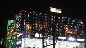 A building with multiple floors, each adorned with colorful lights. - Mystic Moments (Nawada)