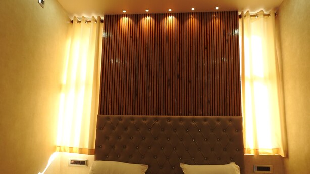 A hotel room with a large bed, two bedside tables, and a headboard with vertical slats. - Mystic Moments (Nawada)