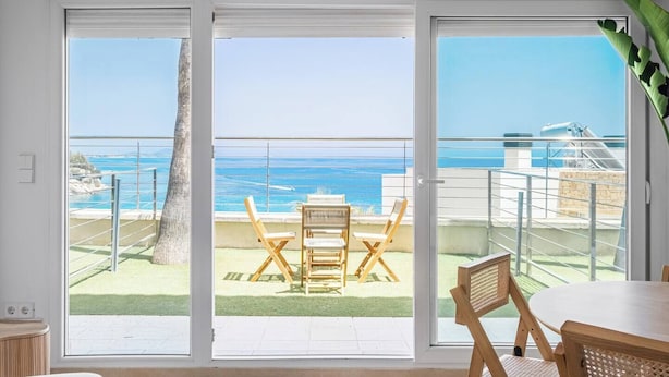 Ein Balkon mit Meerblick, einem Tisch und zwei Stühlen.