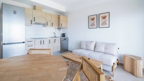 Eine moderne Küche mit Essbereich, einer Couch und zwei gerahmten Kunstwerken an der Wand.