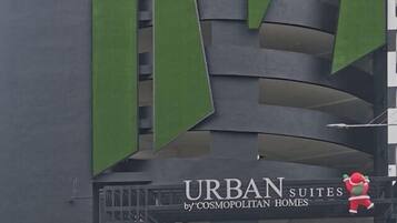A building with a sign that reads "URBAN SUITES by 'COSMOPOLITAN HOMES' with a Santa Claus figure.