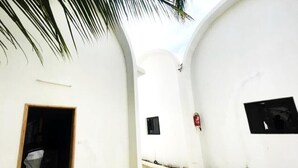 A narrow corridor with white walls, a small door, and a tiled floor. - UBANGUI residence. A unique, calm and inspiring setting! Suitable for creation! (Gandon, Saint-Louis)