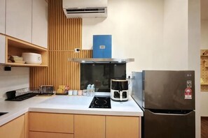 Uma cozinha compacta com fogão embutido, cafeteira e geladeira.