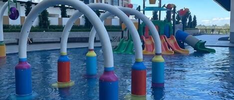 Una piscina con toboganes acuáticos de colores y una zona de juegos de agua.