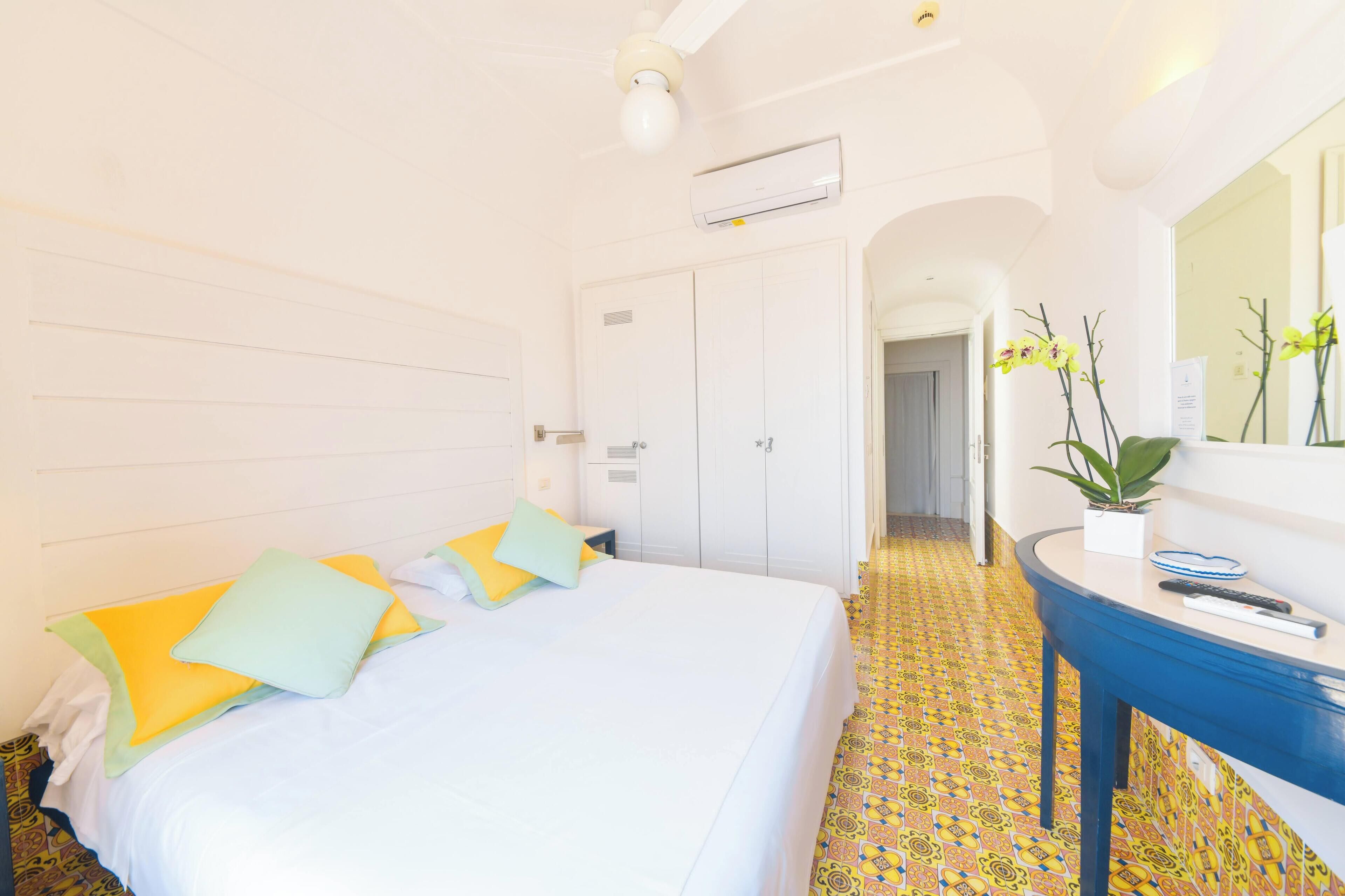 Ein Hotelzimmer mit Bett, Nachttisch und Spiegel.