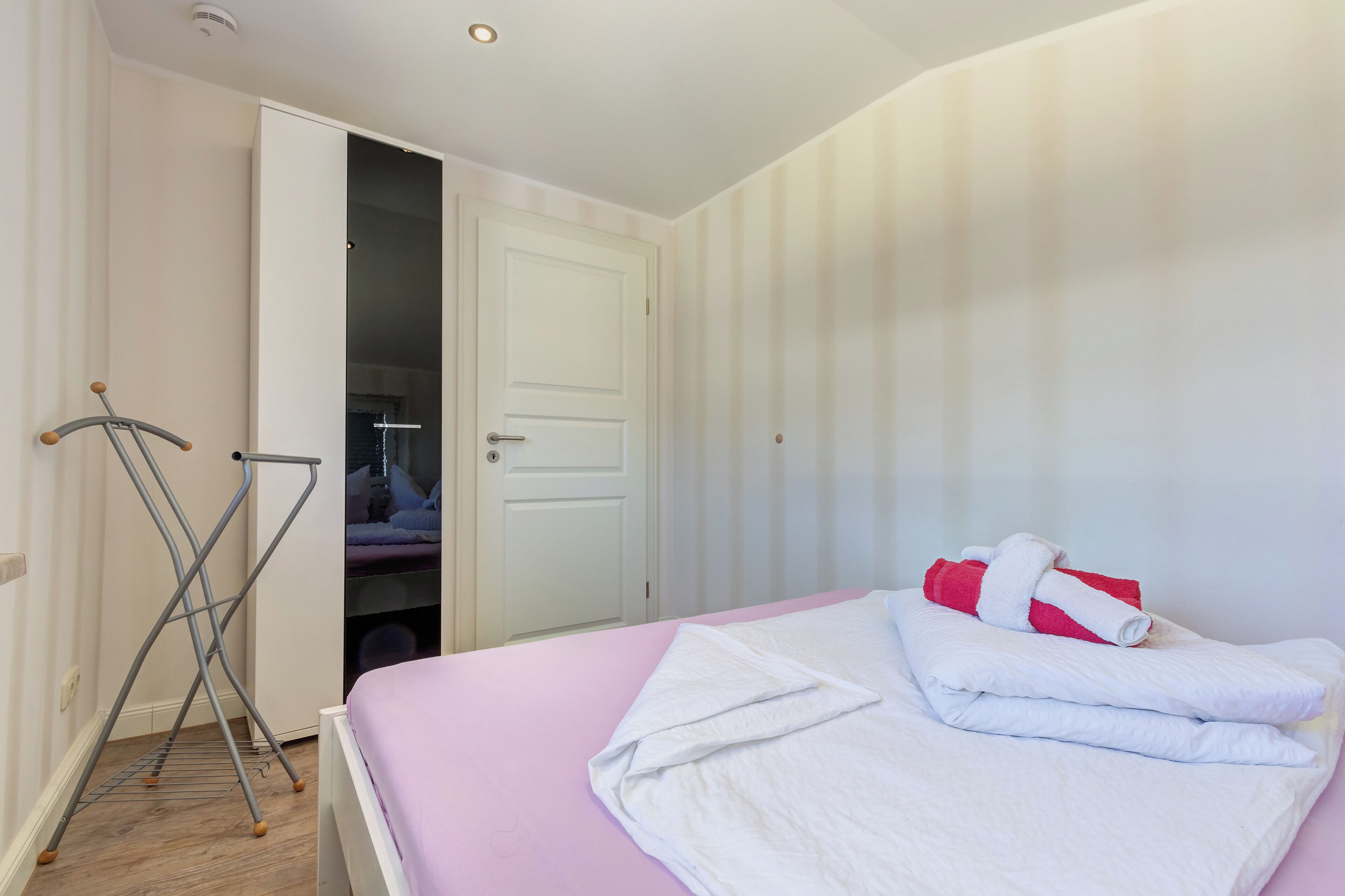 Ein Hotelzimmer mit einem Bett, einem Schrank und einem Wäscheständer.